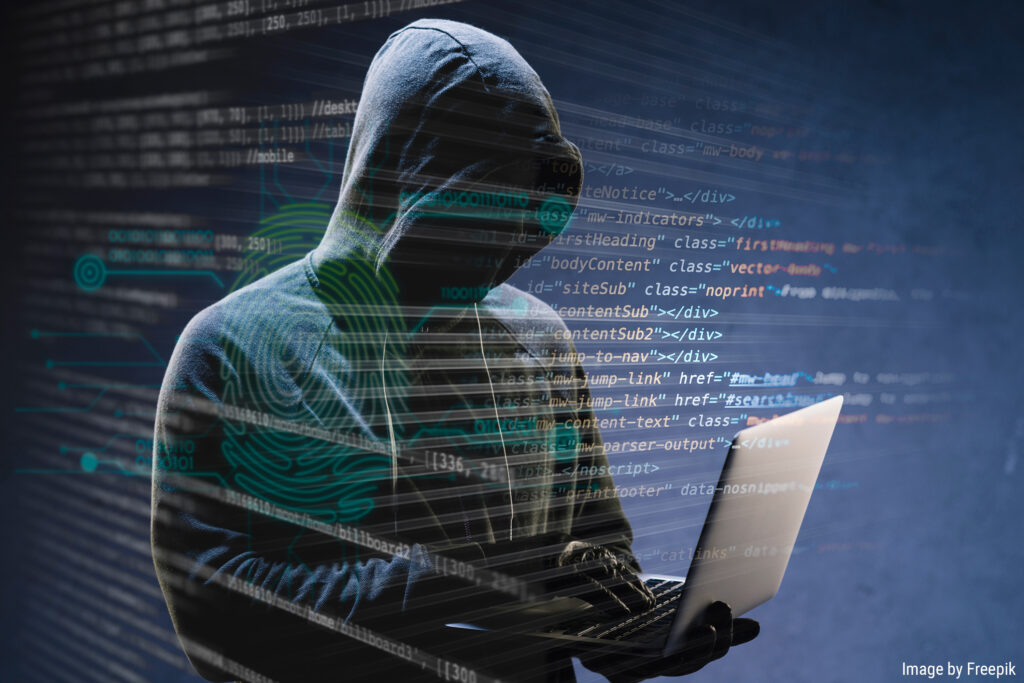 criminel de cybersécurité cagoulé utilisant un ordinateur portable